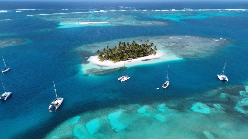 Aerial view of luxury catamarans anchored near a tropical island in San Blas, Panama