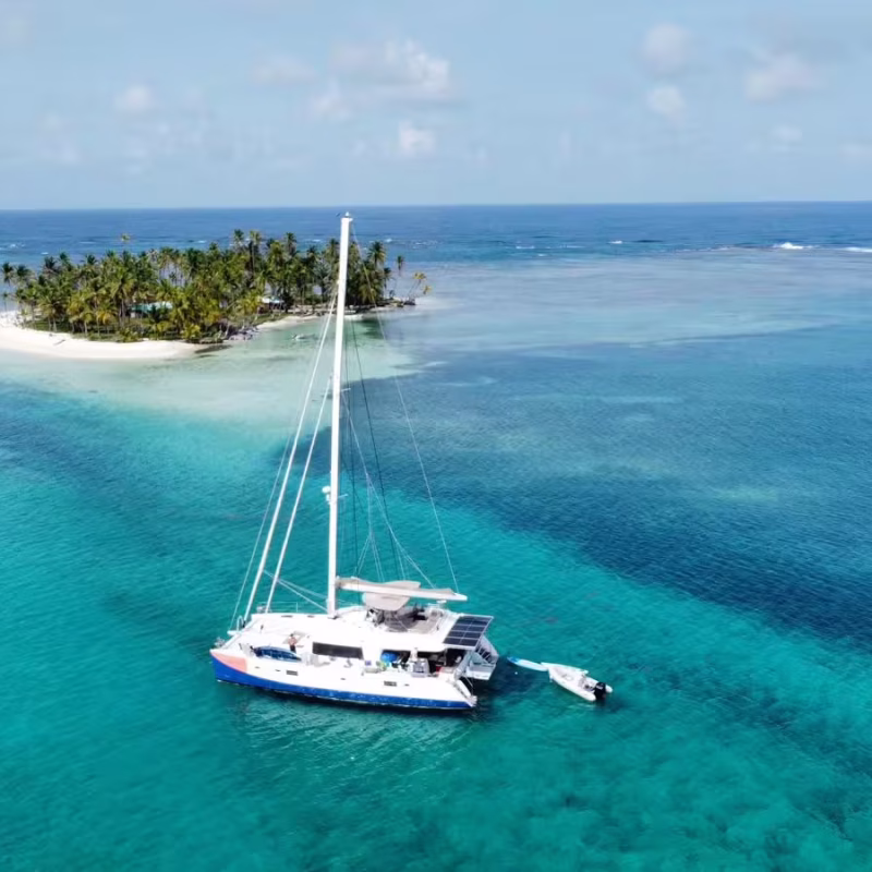 San Blas tropical paradise with sailboat anchored on white sand beach